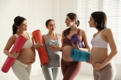 Group of pregnant women with mats in yoga class