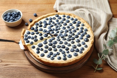 Tasty cake with blueberry on wooden table