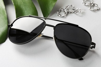 New stylish elegant sunglasses on white table, closeup
