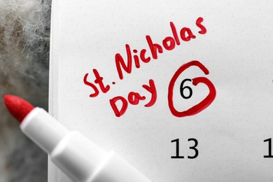 Photo of Saint Nicholas Day. Calendar with marked date December 06 and marker, top view