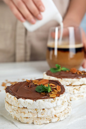 Puffed rice cakes with chocolate spread on white wooden table