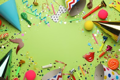Frame of festive items on light green background, flat lay with space for text. Surprise party concept