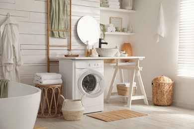 Photo of Stylish bathroom interior with modern washing machine