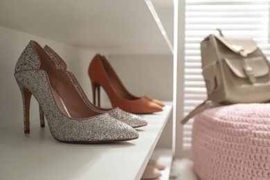 Storage rack with stylish women's shoes indoors, closeup