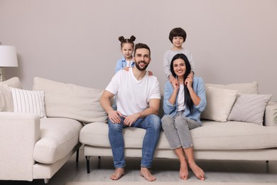 Photo of Portrait of happy family on sofa in living room