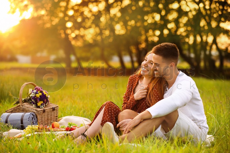 Happy young couple having picnic in park