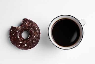 Tasty donut and cup of coffee on white background, flat lay