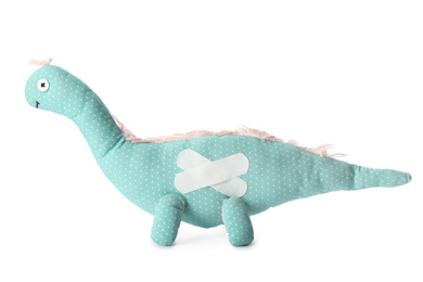 Toy dinosaur with sticking plasters isolated on white