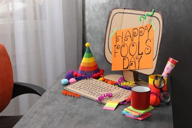 Fake computer with words Happy Fool's Day on table in office