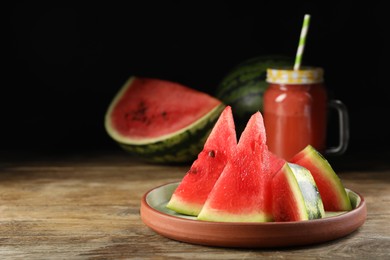 Plate with slices of juicy watermelon on wooden table, space for text