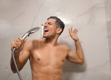 Handsome man singing while taking shower at home