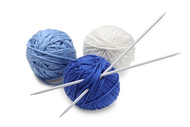 Soft woolen yarns with knitting needles on white background