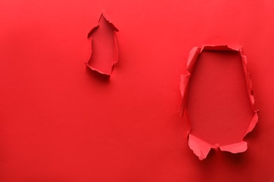 Photo of Holes in red paper on color background