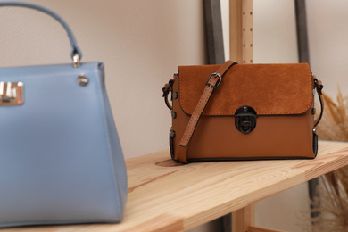 Stylish woman's bags on shelf in boutique