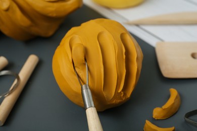 Photo of Clay and set of modeling tools on table, closeup
