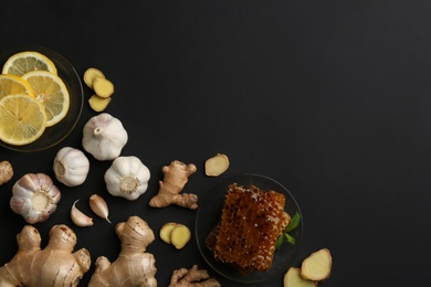 Photo of Ginger and other natural cold remedies on black table, flat lay. Space for text