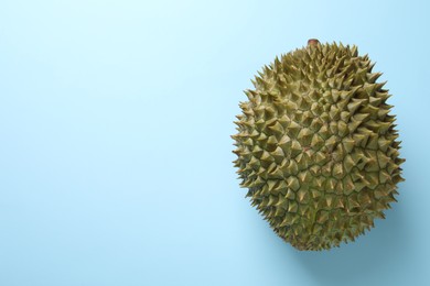 Fresh ripe durian on light blue background, top view. Space for text