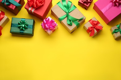 Many colorful gift boxes on yellow background, flat lay. Space for text