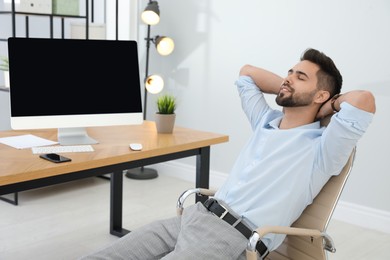 Young businessman relaxing in office chair at workplace
