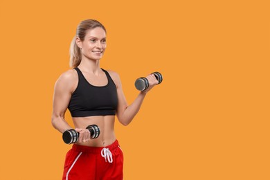 Photo of Sportswoman exercising with dumbbells on yellow background, space for text