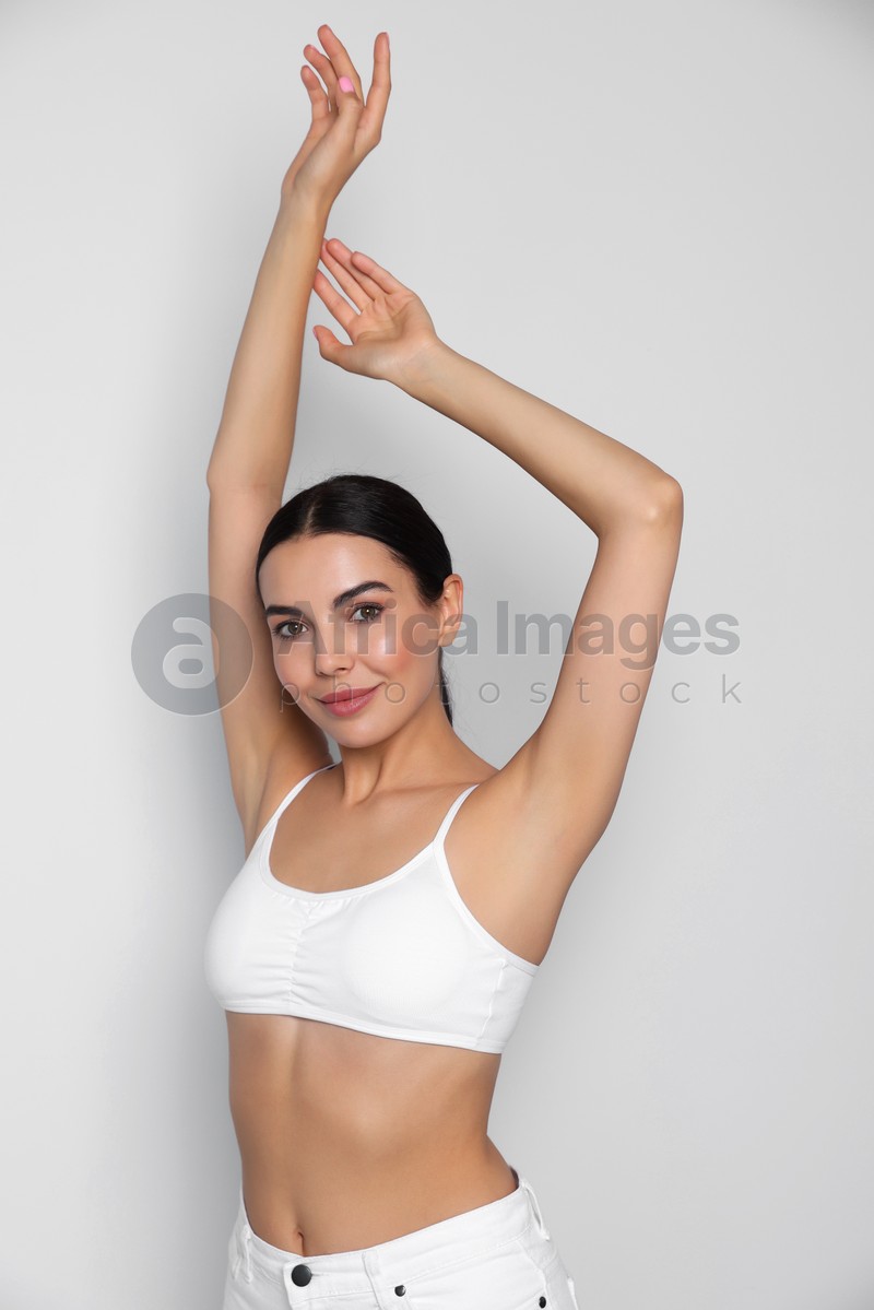 Photo of Young woman showing smooth skin after epilation on white background