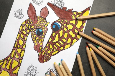 Coloring page with children drawing and set of pencils on grey table, flat lay
