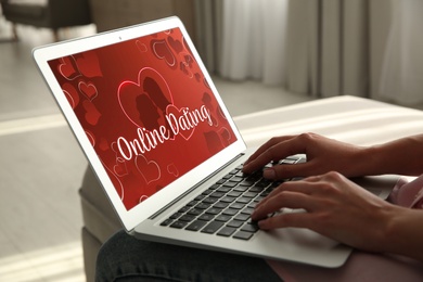 Woman visiting dating site via laptop indoors, closeup