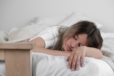 Photo of Tired young woman sleeping in bed indoors