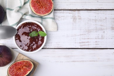 Photo of Tasty sweet fig jam and fruits on white wooden table, flat lay. Space for text
