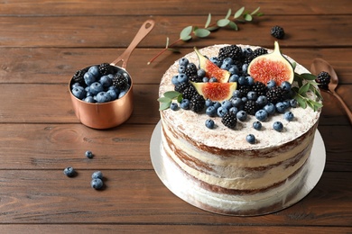 Delicious homemade cake with fresh berries served on wooden table
