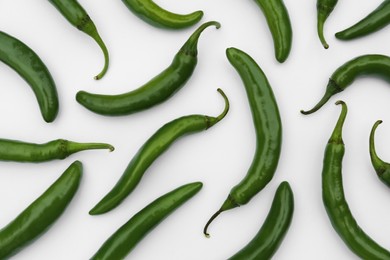 Photo of Many green hot chili peppers on white background, flat lay