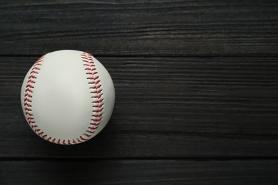 Photo of Baseball ball on black wooden table, top view with space for text. Sports game