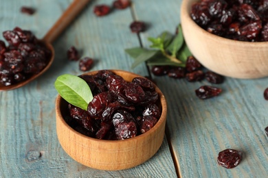 Tasty dried cranberries on blue wooden table