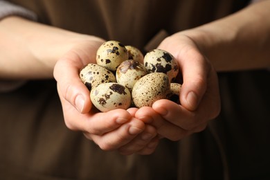 Photo of Woman with handful of quail eggs, closeup