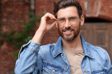 Smiling handsome bearded man with glasses outdoors