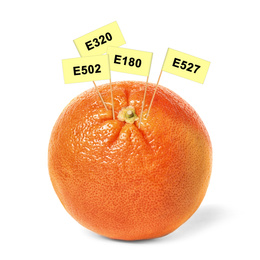 Fresh orange with E numbers isolated on white. Harmful food additives 
