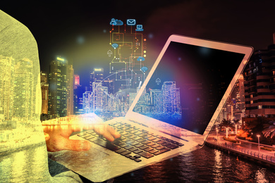 Young man with laptop and virtual image of city, closeup. Modern technology