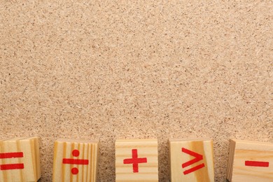 Photo of Wooden cubes with mathematical symbols on fiberboard, flat lay. Space for text