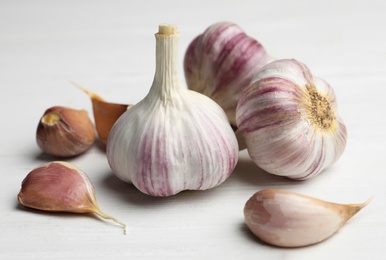 Fresh organic garlic on white wooden table, closeup