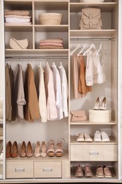 Modern wardrobe with clothes, shoes and accessories indoors