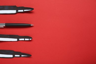 Photo of Information warfare concept. Paper bullets and pen on red background, flat lay with space for text