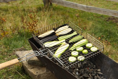 Cooking delicious zucchini on metal grid for barbecue outdoors