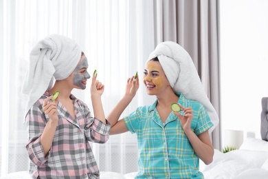 Young friends with facial masks having fun in room at pamper party