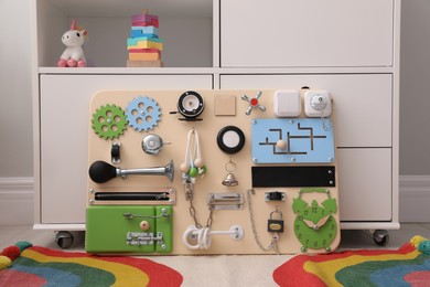 Busy board on floor indoors. Baby sensory toy