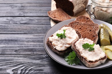 Photo of Delicious sandwiches with lard spread on black wooden table, closeup