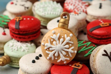 Photo of Beautifully decorated Christmas macarons on plate, closeup