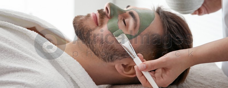 Cosmetologist applying mask on client's face in spa salon. Banner design