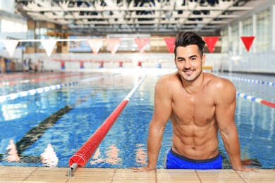 Young athletic man in swimming pool indoors