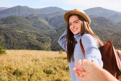 Young woman with her boyfriend in mountains on sunny day