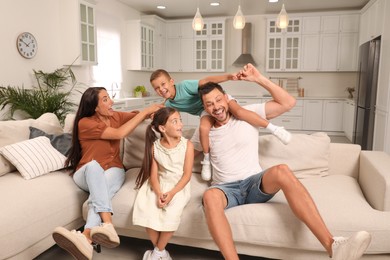 Happy family with children having fun on sofa at home